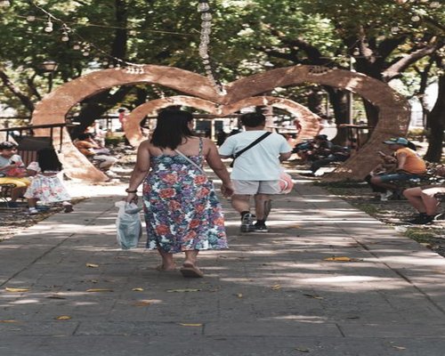 A sunny afternoon in a local park in Guadalajara, Mexico with people walking calmly